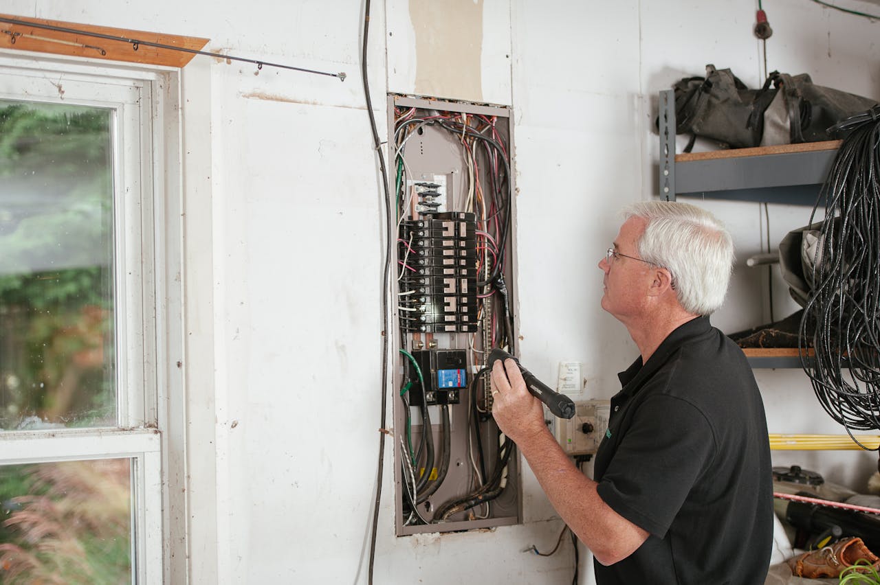 Mastering the First Impression: Your intriguing post title goes here An electrician carefully examines a residential fuse box indoors, ensuring electrical safety and compliance.