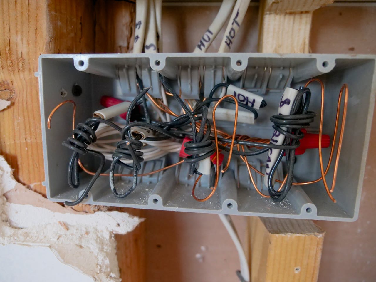 Services Detailed view of an open electrical switchboard with tangled wires and cables.